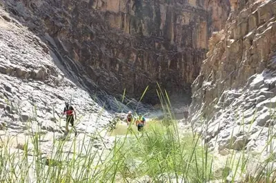 a group of people walking through a canyon at Alhidan Hostel & adventure in Madaba