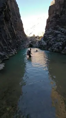 a man kneeling in the water in a river at Alhidan Hostel & adventure in Madaba
