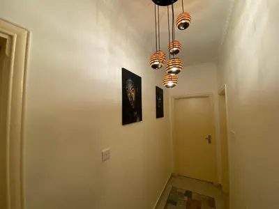 a hallway with a room with a light fixture at Lovely 3-bedrooms rental unit in Aqaba