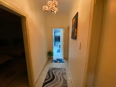 a hallway with a staircase and a chandelier at Lovely 3-bedrooms rental unit in Aqaba