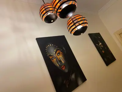 a painting of a mask on a wall with lights at Lovely 3-bedrooms rental unit in Aqaba
