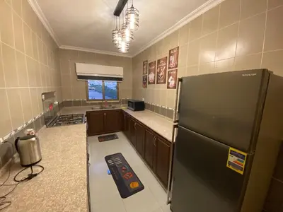a kitchen with a black refrigerator in a room at Lovely 3-bedrooms rental unit in Aqaba
