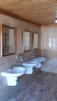 a row of sinks in a bathroom with mirrors at Obeid's Bedouin Life Camp in Wadi Rum