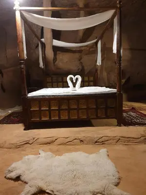 a bedroom with a bed with a white canopy and a white rug at Obeid's Bedouin Life Camp in Wadi Rum