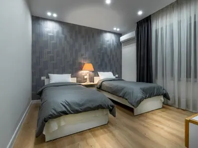 a bedroom with two beds and a table with a lamp at Prestige Hotel Suites - برستيج للشقق الفندقية in Amman