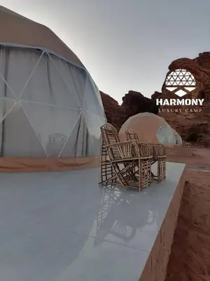 a couple of wicker chairs sitting in front of a tent at Harmony Luxury Camp in Wadi Rum