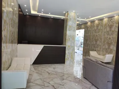 a lobby with two chairs and a reception desk at Golden Hotel in Amman
