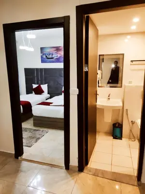 a room with a bed and a bathroom with a mirror at Golden Hotel in Amman