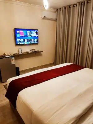 a hotel room with a bed and a flat screen tv at Golden Hotel in Amman