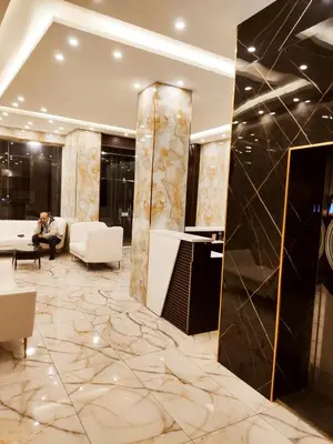 a lobby with a person sitting on a couch at Golden Hotel in Amman