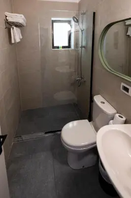 a bathroom with a shower and a toilet and a sink at Julia's Hotel Suites in Amman
