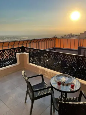 a balcony with a table and chairs and a view of the ocean at Villa Jana Chalet in Ash Shāghūr