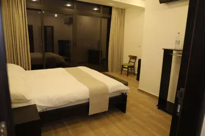 a bedroom with a bed and a large window at Follow Sea Villa in Sowayma
