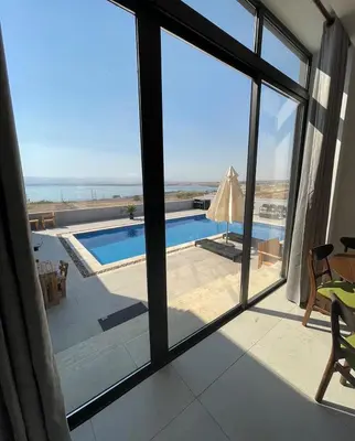 a view of a pool from a room with a window at Follow Sea Villa in Sowayma