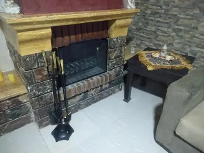 a living room with a brick fireplace and a table at City Center Furnished Apartment in Madaba