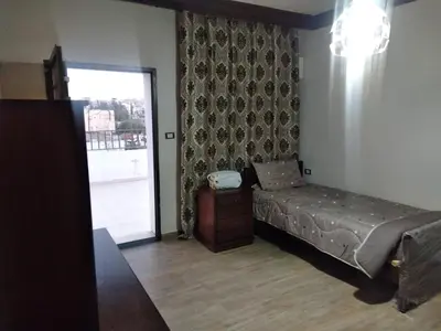 a bedroom with a bed and a sliding glass door at City Center Furnished Apartment in Madaba