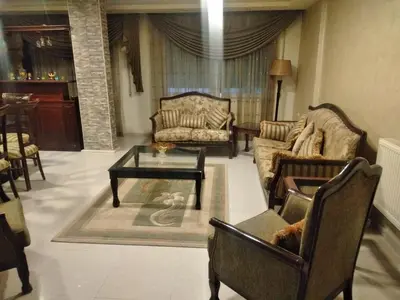 a living room with couches and a coffee table at City Center Furnished Apartment in Madaba