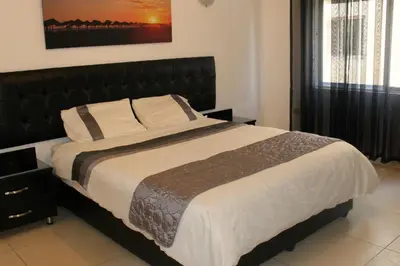 a bedroom with a large bed with a black headboard at The Place Apartments in Amman