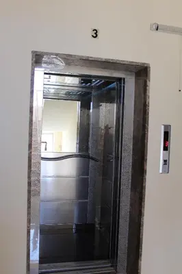 a mirror with a reflection of a door in a room at The Place Apartments in Amman