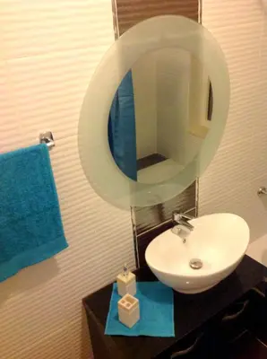 a bathroom with a sink and a mirror at The Place Apartments in Amman
