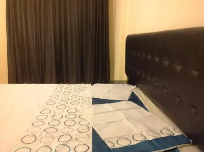 a bedroom with a bed with a black head board at The Place Apartments in Amman