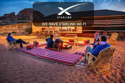 a group of people sitting in chairs in front of a building at Mohammed Mutlak Camp in Wadi Rum
