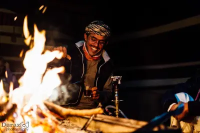 a man standing in front of a fire at Mohammed Mutlak Camp in Wadi Rum