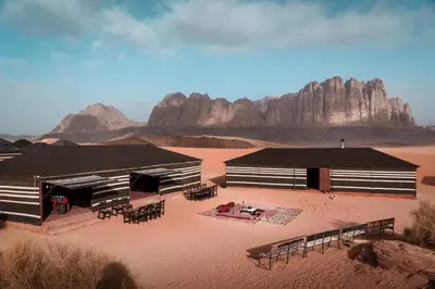 a building in the desert with tables and chairs at Mohammed Mutlak Camp in Wadi Rum