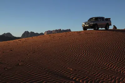 a truck parked on top of a sand dune at Mohammed Mutlak Camp in Wadi Rum
