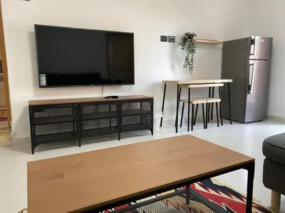 a living room with a flat screen tv on a wall at Lemon Tree Residence in Amman