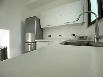 a kitchen with white cabinets and a sink at Lemon Tree Residence in Amman