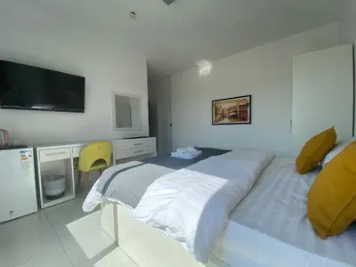 a bedroom with a bed and a desk and a television at Lemon Tree Residence in Amman