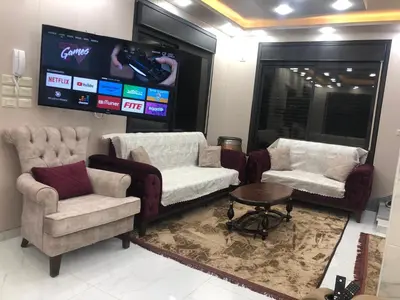 a waiting room with two chairs and a tv at Abu Hossam s chalet in Jerash