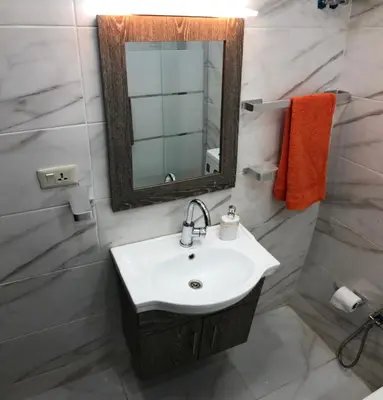 a bathroom with a sink and a mirror at Abu Hossam s chalet in Jerash