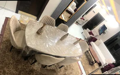 a dining table and chairs in a living room at Abu Hossam s chalet in Jerash