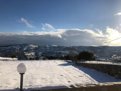 a snow covered road with mountains in the background at Abu Hossam s chalet in Jerash