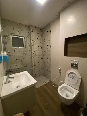 a bathroom with a toilet and a sink at bedroom (3) apartment of 200 square meters with an outdoor terrace in Umm Uthainah