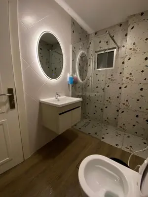 a bathroom with a sink and a toilet and a mirror at bedroom (3) apartment of 200 square meters with an outdoor terrace in Umm Uthainah