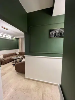 a living room with green walls and a couch at bedroom (3) apartment of 200 square meters with an outdoor terrace in Umm Uthainah