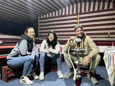 a group of three people sitting in a room at Jawharat Rum camp in Wadi Rum