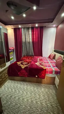 a bedroom with a red bed and red curtains at Issa Snaffi Bedouin home in Wadi Musa