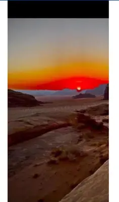 a sunset in the desert with the sun setting at The sunset of Wadi Rum in Wadi Rum
