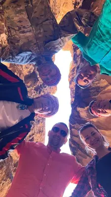 a group of people standing in a rock formation at The sunset of Wadi Rum in Wadi Rum