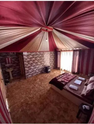 a bedroom with a bed with a red ceiling at The sunset of Wadi Rum in Wadi Rum
