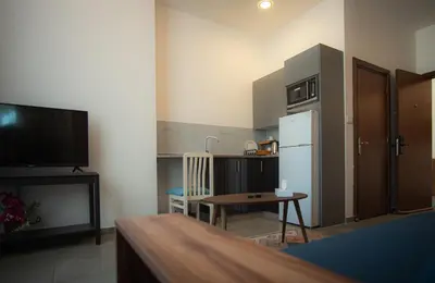 a kitchen with a refrigerator and a table in a room at Weibdeh Heights Hotel Suites in Amman