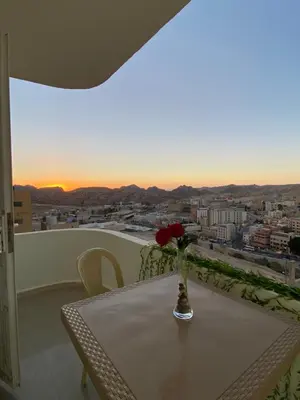 a vase with a flower on a table on a balcony at Hustle's look in Wadi Musa