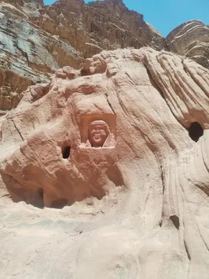 a rock formation with a face in a window at Rum desert camp in Wadi Rum