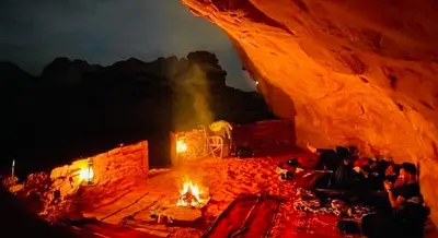 a group of people in a cave at night at Bedouin Desert Cave in Wadi Rum