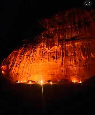 a rock formation with lights on it at night at Bedouin Desert Cave in Wadi Rum