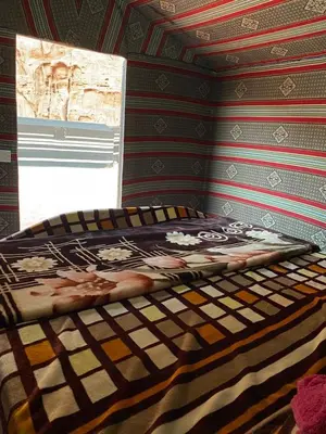 a bed sitting in a room with a window at Bedouin Desert Cave in Wadi Rum